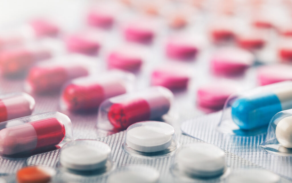 Heap of medical pills in white, blue and other colors