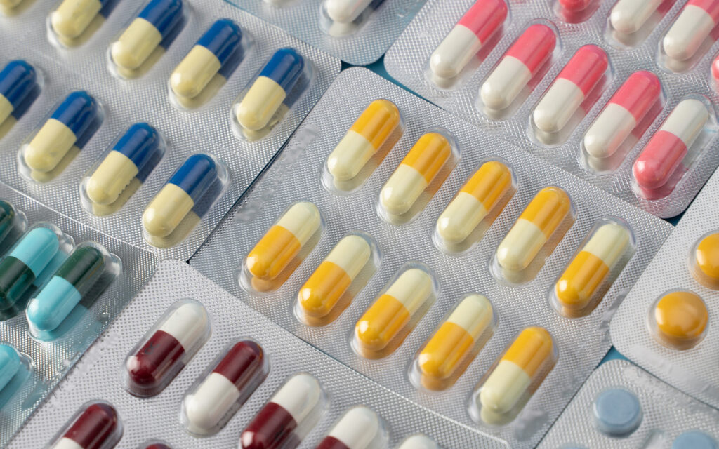 Top-down view of pills with many different colors in blister packaging